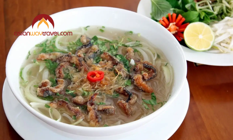 Hot Vietnamese noodle soup with grilled eel and fresh herbs