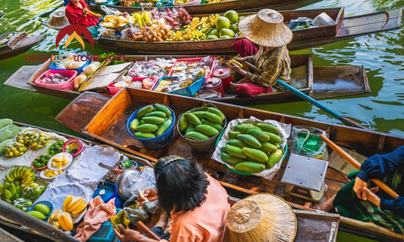 Floating market in Bangkok with fruit vendors on traditional boats